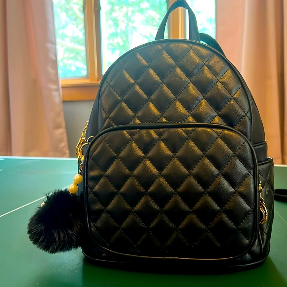 Kids mini black backpack with mini compartments inside and keychain on zipper